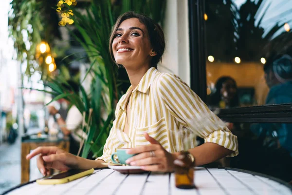 Χαρούμενη Νεαρή Γυναίκα Casual Ντύσιμο Κάθεται Στο Τραπέζι Φλιτζάνι Φρέσκο — Φωτογραφία Αρχείου