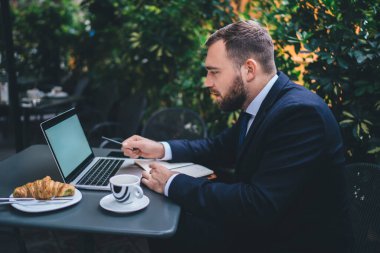 Sokak kafesindeki 4G internete bağlı online yatırımı analiz etmek için dizüstü bilgisayar kullanan erkek girişimci, fotokopi alanı olan boş bir ağdaki boş internet bilgilerine göz attı
