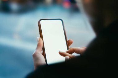 İnternet 'te dijital cep telefonuyla sörf yapan anonim kız öğrencilerin arka plan görüntüsü, şehir sokaklarında ders aralarında mola verirken...