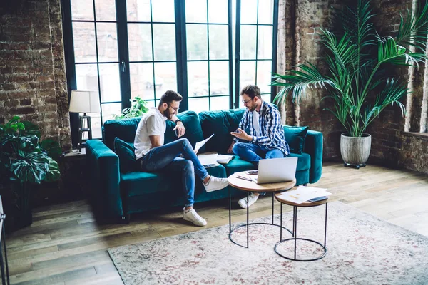 Empresarios Con Ropa Casual Sentados Sofá Leyendo Nuevos Informes Mientras —  Fotos de Stock