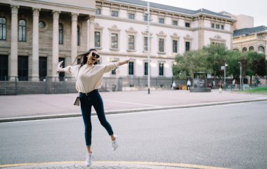 Keyfi yerinde Asyalı bir kadın sokakta rahatça zıplayıp kaygısız ve şaşırtıcı bir şekilde tatil yerlerine gidiyor. Seyahatin tadını çıkaran genç bir turist ve şehir arka planına atlıyor.