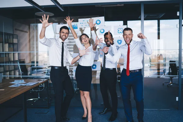 完成した事業プロジェクトを祝いながら手を挙げた男女の従業員のグループ 幸せな起業家は 企業のオフィスでのコラボレーションブレインストーミングに満足 — ストック写真