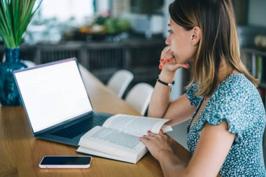 Eğitim sırasında internet sitesinde gezinen, ciddi bir beyaz kız öğrenci, eğitim üzerine kitap harcaması yapan ve dizüstü bilgisayar kullanan yetenekli bir kadın milenyum.