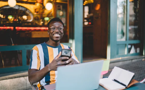 Junge Afroamerikanische Freiberufler Lässigem Shirt Und Brille Mit Smartphone Schreibtisch — Stockfoto