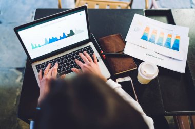 Finansal eğitim için üniversite sınavlarına hazırlanan kadın öğrencilerin en iyi görüşü, sergilenen ticari bilgi grafiklerini analiz ederken, netbook 'ta profesyonel kurgu gelirleri analitiği