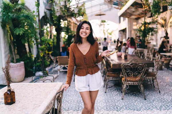 Ευτυχισμένη Νεαρή Ασιάτισσα Στέκεται Άνετο Εστιατόριο Κοντά Στο Τραπέζι Χέρι — Φωτογραφία Αρχείου
