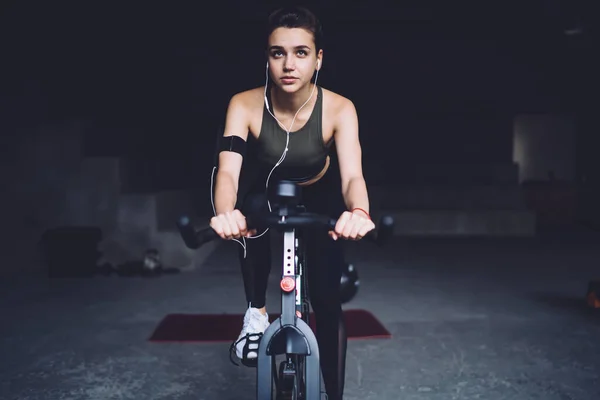 Mulher Caucasiana Determinada Fones Ouvido Sentado Bicicleta Exercício Pronto Para — Fotografia de Stock