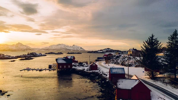 Norveç deniz suyuyla kaplı Lofoten takımadalarının nefes kesici kuş bakışı görüntüsü. Küçük balıkçı teknesinin hava görüntüsü. Altın gün batımında iskelesi olan. 