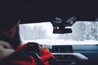 Kış mevsiminde çevre odunlarında otonomobil kullanan bir adamın görüntüsü. Kış karasal seyahati sırasında ulaşımdan keyif alan adamın sigortası var.