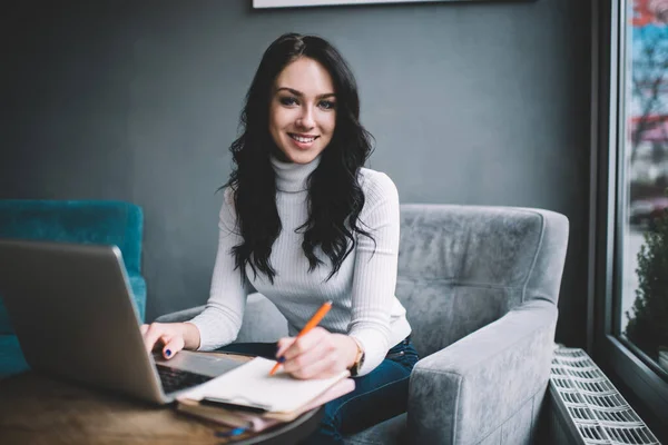 Glimlachende Vrouwelijke Manager Zit Aan Tafel Met Laptop Tegen Kantoorraam — Stockfoto