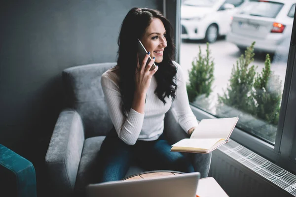 Leende Kvinnlig Frilansare Sitter Kreativ Arbetsplats Och Pratar Mobiltelefon Medan — Stockfoto