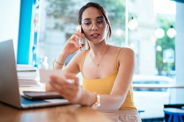 Concentrated Young Female Employee Calling Phone Number Business Card While — Stock Photo, Image
