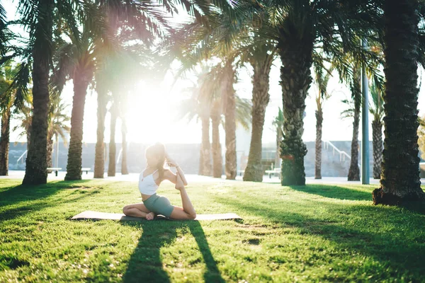 Flexible Caucasian female enjoying yoga retreat feeling body recreation and harmony during morning meditation, woman doing asana on mat getting inspiration keeping fit and healthy lifestyle