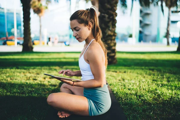 Atleta Feminina Caucasiana Sentada Tapete Treino Usando Tecnologia Touch Pad — Fotografia de Stock