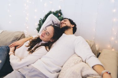 Beyaz kadın, güzel erkek arkadaşının yanında yatıyor. Kış tatillerinden memnun. Hoş, süslü bir dairede tatiller geçiriyor.