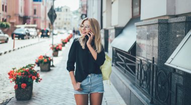 Kaygısız kadın gezmek için modern cep telefonu aygıtını kullanıyor. Tatil tatillerinde şehri keşfediyor. Güneş gözlüklü mutlu bir turist.