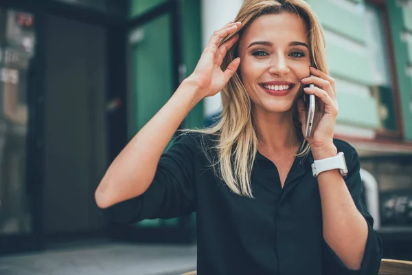 Portrait of happy hipster girl with perfect candid smile enjoying positive mobile phoning for talking, cheerful Caucasian woman contact best friend making international conversation in roaming