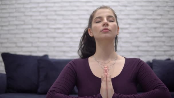 Привлекательная женщина медитирует дома, йога поза лотос, расслабляющий, namaste руки — стоковое видео