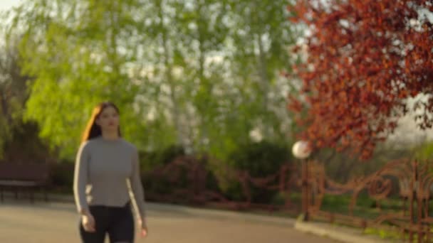 Mujer caminando en el parque al atardecer — Vídeo de stock