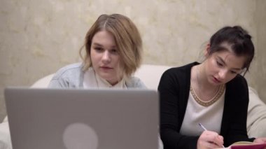 Evde internet üzerinden eğitim alan kadın öğrenciler ev ofisinde çalışıyor.