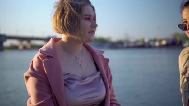 Dos mujeres jóvenes en muelle, caminando por la calle, amigos hablando, concepto de amistad — Vídeos de Stock