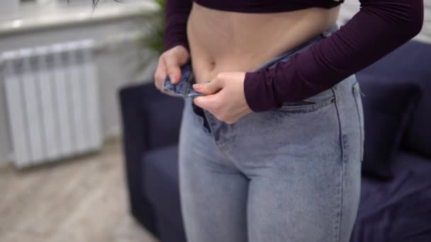 Overweight woman measuring waist with too small jeans, pulling up tight jeans — Stock Video