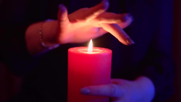 Frau hält Hände unter Kerzenfeuer, magisches mystisches Ritual, okkulte Esoterik — Stockvideo