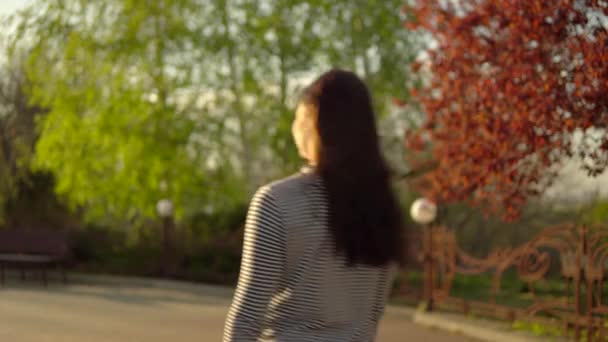 Mujer caminando en el parque de la ciudad, atardecer — Vídeos de Stock
