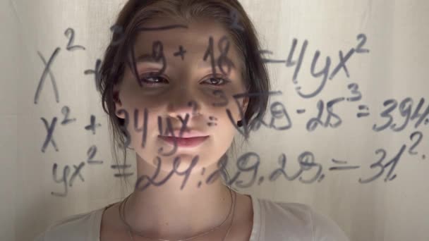 Studente donna guardando equazione matematica sulla lavagna di vetro, pensando — Video Stock