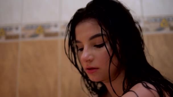 Joven chica mojada en el baño mirando a la cámara untada rímel cabello mojado aspecto dramático — Vídeo de stock