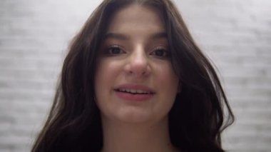 Çekici kadın görüntülü konuşma yapıyor, kameraya bakıyor ve konuşuyor.