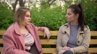 Genç çekici kadınların konuşması, parkta yürümesi, arkadaşlık kavramı.