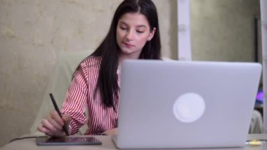 Tablet ve kalem kullanarak çalışan kadın tasarımcı ofis çalışanı