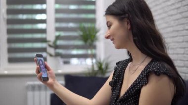 Çekici bir kadın cep telefonundan arkadaşıyla görüntülü konuşma yapıyor.