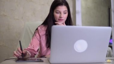 Tablet ve kalem kullanarak çalışan kadın tasarımcı ofis çalışanı