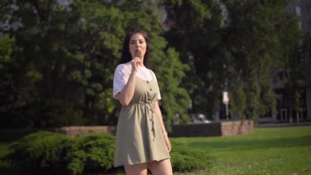 Joven atractiva mujer waliking comer helado al aire libre vacaciones de verano — Vídeo de stock