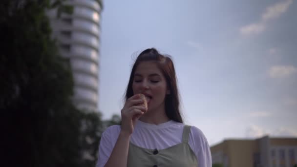 Zomer wandelen in het stadspark, aantrekkelijke vrolijke vrouw eten ijs close-up — Stockvideo
