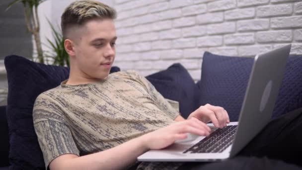 Jonge aantrekkelijke man freelancer afstand werken met lapotop, programmeur huis — Stockvideo