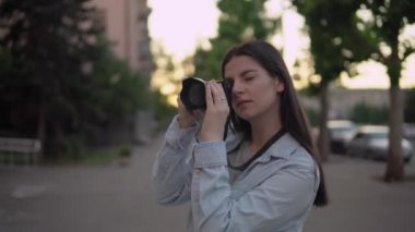 Şehirde fotoğraf makinesiyle çalışan çekici kadın fotoğrafçı.