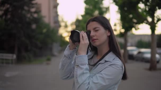 Ελκυστική γυναίκα φωτογράφος που εργάζονται στην πόλη με φωτογραφική μηχανή — Αρχείο Βίντεο