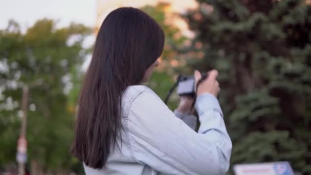 Женщина-фотограф работает на улице, используя фотокамеру — стоковое видео