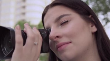 Kameralı kadın fotoğrafçı, fotoğraf içeriği yapıyor, portreyi kapatıyor.