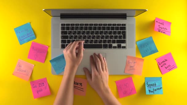 Використовуючи руки для друку ноутбуків, розміщуйте документи на робочому місці, нагадуйте наклейки на столі — стокове відео