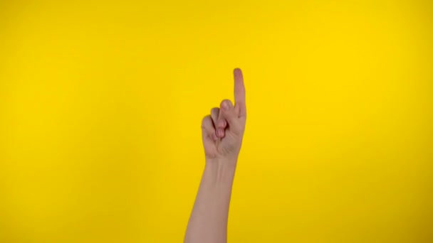 Tangan muncul, isyarat tangan pada latar belakang kuning — Stok Video