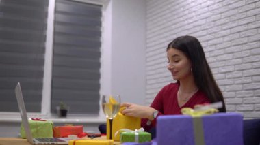 Videodaki kadın konuşuyor, hediye paketi yapıyor, el yapımı hediyeler hazırlıyor.