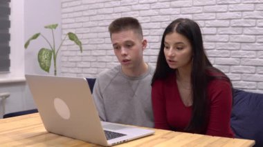 Üzgün, ciddi bir çift görüntülü konuşuyor. Laptop kullanıyor, kötü haberler veriyor.