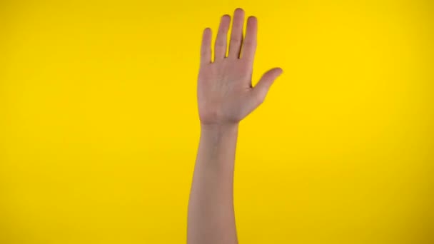 Mão acenando no fundo amarelo, diga Oi, diga olá por gestos — Vídeo de Stock