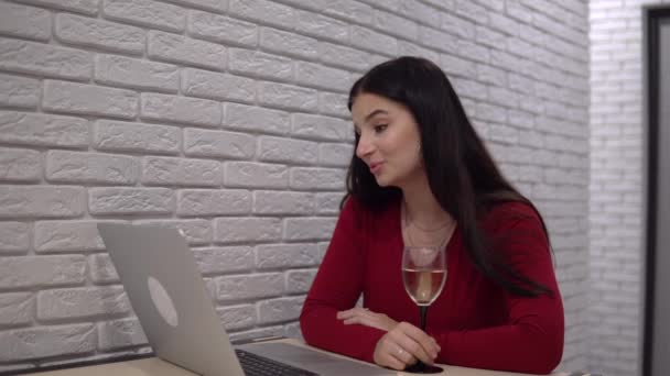 Attraktive Frau, die sich per Videochat unterhält, Distanz zum Online-Treffen, ein Glas Wein — Stockvideo