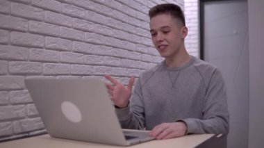 Çekici bir adam görüntülü görüşme, kişisel izolasyon, dizüstü bilgisayar.