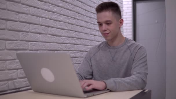 Mann som jobber med bærbar datamaskin, frilanser på fjernarbeid, selvisolering hjemme – stockvideo